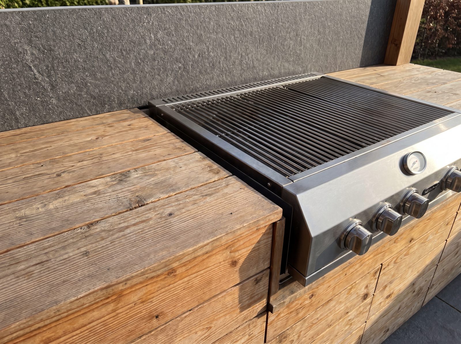 Edelstahl-Einsatz und Sicherheitsabstand zwischen Grill und Holzkorpus einer Outdoorküche